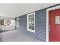 Inviting front porch with red door and gray siding at 1472 N Grant Ave, Indianapolis, IN 46201