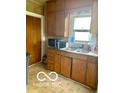 Small kitchen with wood cabinets and double sink at 1317 W Memorial Dr, Muncie, IN 47302