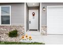 Inviting front entryway with sunflowers and a welcoming wreath at 1431 Coen Ct, Columbus, IN 47201