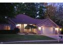 Brick ranch house with two-car garage, lit at night at 466 Sycamore Ridge Ct, Avon, IN 46123