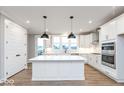 White kitchen featuring an island, stainless steel appliances, and ample natural light at 7310 W County Road 600 Rd # 14-603, McCordsville, IN 46055