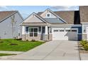 Craftsman style home with gray siding, stone accents, and a two-car garage at 10618 Maidenhair Dr, Indianapolis, IN 46239
