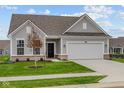 Gray siding one-story home with a two-car garage and landscaped lawn at 16817 Silo Meadows Dr, Noblesville, IN 46060