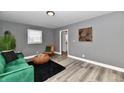 Bright living room with a green sofa, stylish decor, and wood-look floors at 2035 N Tibbs Ave, Indianapolis, IN 46222
