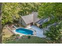 Aerial view of house, in-ground pool, deck, and surrounding woods at 8954 Briarclift Rd, Indianapolis, IN 46256