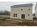 Tan vinyl-sided two-story house with sliding glass door and unfinished yard at 11011 Walter Dr, Indianapolis, IN 46235