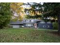 Ranch home with dark blue exterior and landscaping at 6205 Bramshaw Rd, Indianapolis, IN 46220