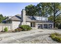 House exterior features stone facade, triple garage, and landscaping at 6502 Allisonville Rd, Indianapolis, IN 46220