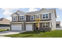 Two story home with gray siding and brick accents, two-car garage at 6429 Flag Stop Dr, Whitestown, IN 46075