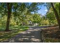 Long driveway leading to a Tudor style home, surrounded by lush trees at 6470 Around The Hills Rd, Indianapolis, IN 46226