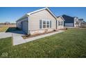 Side view of a ranch home with attached garage and landscaping at 7920 Magnolia St, New Palestine, IN 46163