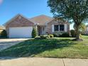 Ranch-style brick home with attached garage and lush lawn at 1841 Holiday Pines Dr, Brownsburg, IN 46112