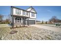 Two-story home with gray and white exterior, brick accents, and a two-car garage at 1642 Orchard Dr, Fortville, IN 46040