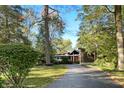 Mid-century modern home with a long driveway, surrounded by trees at 4024 W South Wood Lake Dr, Columbus, IN 47201