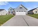 Front view of a two-story home with gray siding, stone accents, and a two-car garage at 408 Charles Freer Ln, Whiteland, IN 46184