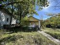 Yellow bungalow with front porch and mature trees at 3221 E 38Th St, Indianapolis, IN 46218