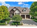 Elegant home exterior with mature trees and landscaping at 15571 Bridgewater Club Blvd, Carmel, IN 46033