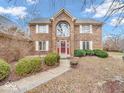 Two-story brick home with a red front door and landscaping at 50 Charing Cross Rd, Indianapolis, IN 46217