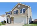 Two-story house with beige siding, white garage door, and landscaping at 4633 Angelica Dr, Indianapolis, IN 46237