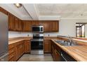 Galley kitchen with stainless steel appliances and wood cabinets at 8168 Shorewalk Dr # A, Indianapolis, IN 46236