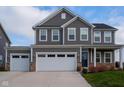Two-story gray house with white garage doors and stone accents at 16703 Ayshire Dr, Fishers, IN 46037