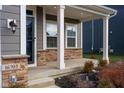 Covered porch with white columns, stone accents, and a glass door at 16703 Ayshire Dr, Fishers, IN 46037