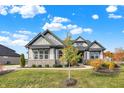 Two-story house with gray and white exterior, stone accents, and landscaping at 12594 Tidecrest Dr, Fishers, IN 46037