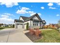 House exterior with gray and white siding, stone accents, and a two-car garage at 12594 Tidecrest Dr, Fishers, IN 46037