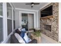 Relaxing covered patio with fireplace, seating area, and outdoor TV at 1939 Ponsonby Dr, Westfield, IN 46074