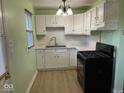 Charming kitchen with white cabinets, light green walls, and modern appliances at 6150 Oak Ave, Indianapolis, IN 46219