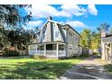 Gray sided two-story house with white porch and driveway at 3616 N College Ave, Indianapolis, IN 46205