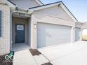 Three-car garage with light gray doors and brick exterior at 2298 Pine Valley Dr, Plainfield, IN 46168
