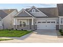 Two-car garage craftsman style home with gray siding and stone accents at 10549 Maidenhair Dr, Indianapolis, IN 46239