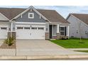 Ranch style home with gray siding, white trim, and a two-car garage at 10612 Maidenhair Dr, Indianapolis, IN 46239