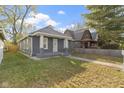Gray brick house with a white door, small porch, and a grassy yard at 1141 W 31St St, Indianapolis, IN 46208
