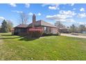 Side view of brick ranch home with landscaping and driveway at 521 Eagle Crest Dr, Brownsburg, IN 46112