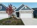 Two-story home with stone and blue siding, two-car garage, and landscaping at 17066 Cole Evans Dr, Noblesville, IN 46060