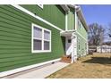 Side view of a green house with white trim and a side entrance at 2429 N Rural St, Indianapolis, IN 46218