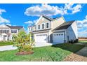 Two-story house with taupe siding, white trim, and a three-car garage at 5856 Fair Oak Cir, Brownsburg, IN 46112
