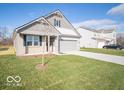 Two-story house with gray siding, a two-car garage, and a well-manicured lawn at 8834 Glacier Bay Ct, Camby, IN 46113