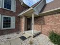 Covered entryway with brick facade and a decorative door at 2413 Griton Ct, Shelbyville, IN 46176