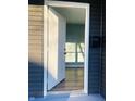 Open white door revealing a light teal living room with hardwood floors at 1601 Draper St, Indianapolis, IN 46203