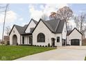 White brick house with a black roof, driveway, and landscaping at 10771 Holliday Farms Blvd, Zionsville, IN 46077