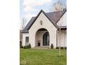 Elegant arched entryway with a black metal door and white brick at 10771 Holliday Farms Blvd, Zionsville, IN 46077