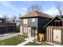 Modern two-story home with gray and wood siding, landscaping, and a walkway at 1514 E 12Th St, Indianapolis, IN 46201