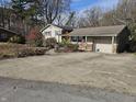 Ranch home with a large concrete driveway and mature trees at 620 Valley Dr, Martinsville, IN 46151