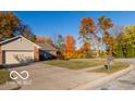 Ranch home with driveway and mature trees in the fall at 304 Chestnut St, Danville, IN 46122