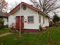 Front view of a quaint house with red trim and a small front yard at 821 N Tuxedo St, Indianapolis, IN 46201