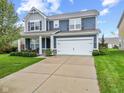 Two-story home with gray and blue siding, a white garage door, and a landscaped front yard at 1285 Greenwood Station Blvd, Greenwood, IN 46143