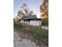 White house with overgrown yard and needs repairs at 1656 Nelson Ave, Indianapolis, IN 46203